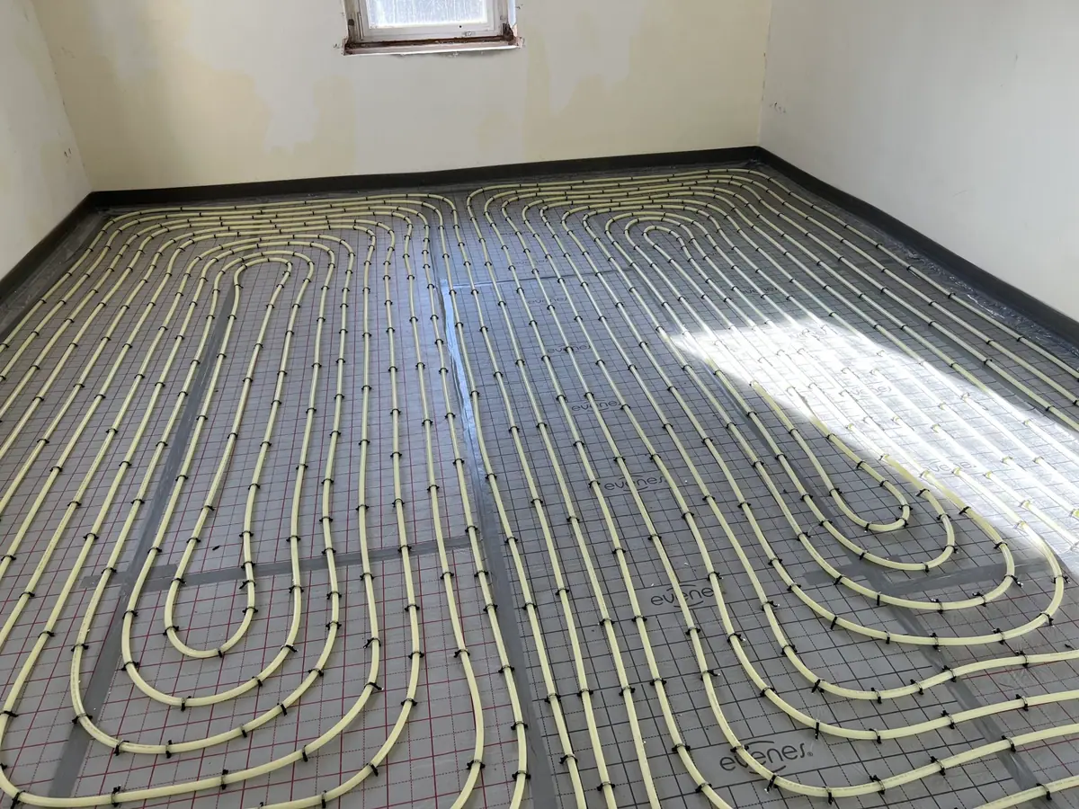 Heizrohre einer Fußbodenheizung in gleichmäßigen Schleifen verlegt